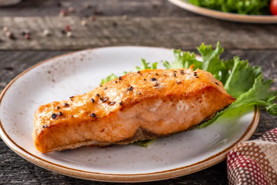 Pan-seared salmon fillet with lemon and dill, highlighting its rich color and texture.